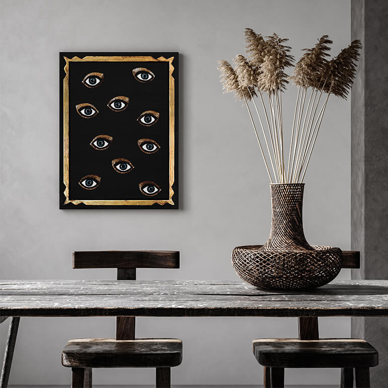 dining room with a framed glam wall décor piece in black and gold with a group of embroidered eyes