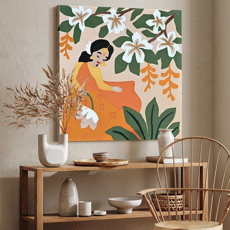 Mood shot of a modern textile artwork showcasing Goddess Sita amidst jungle foliage, canvas framed and displayed in an organic modern style of room by a wooden table