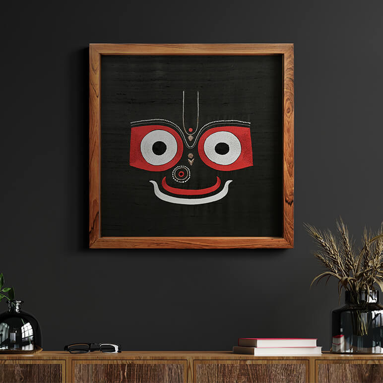 Staged view of Jagannath artwork framed in wood, displayed over a wooden console table on a charcoal black wall