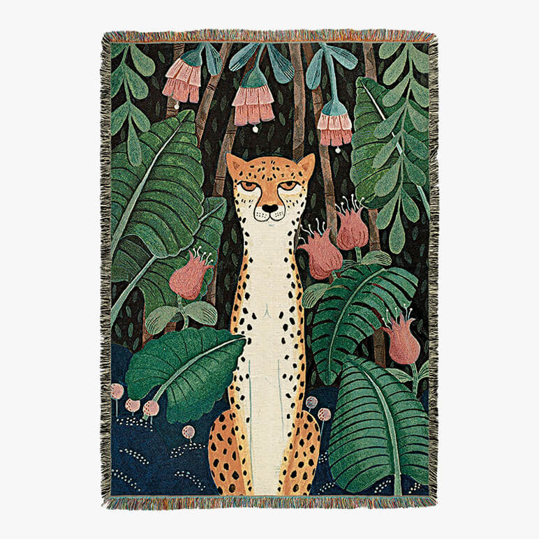 jungle themed woven throw with multicolored tassels, featuring a cheetah sitting in a forest amidst foliage