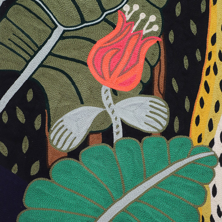 closeup detail of aari embroidery on a textile artwork in multiple colors showing plants with flowers and leaves