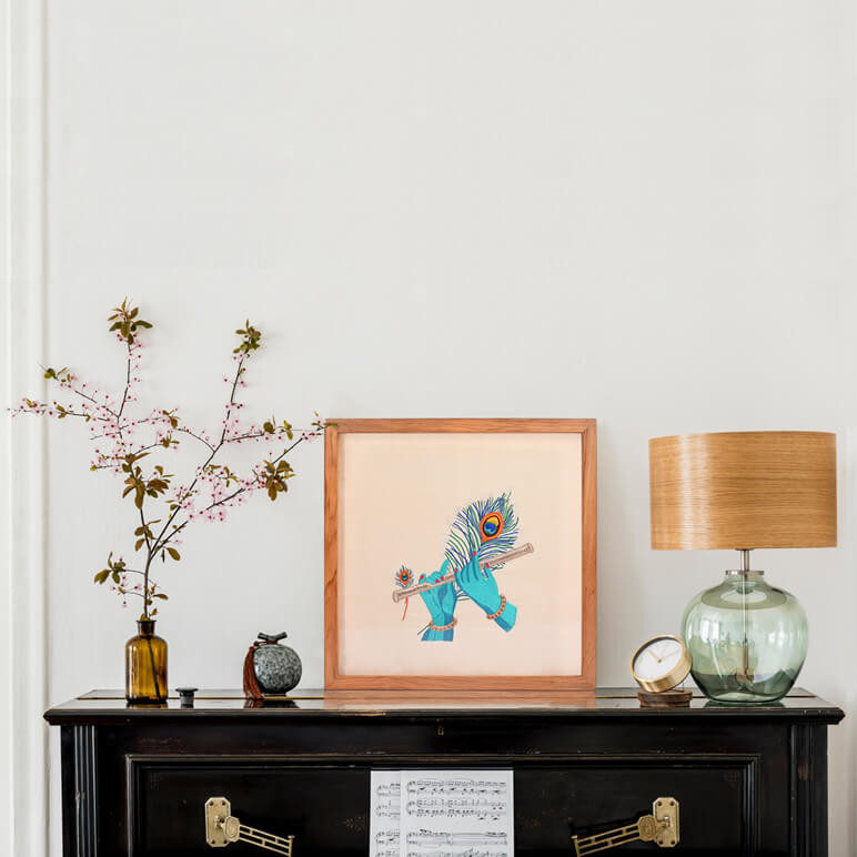Krishna flute artwork seen framed in wood and displayed over a black piano