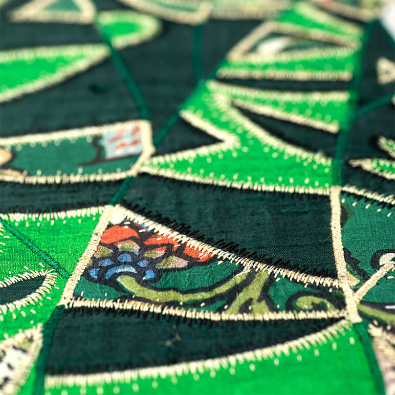 closeup view of the embroidery on a green cactus wall décor piece