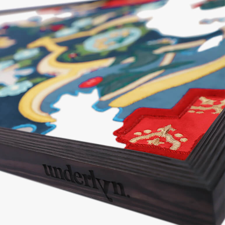 corner detail of a large framed tapestry showing the Underlyn logo etched in black wood