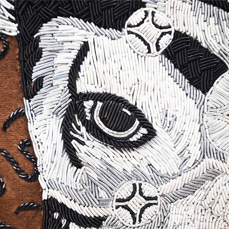 closeup view of the embroidered Bull's eye, crafted using French wire in white, silver and black colors