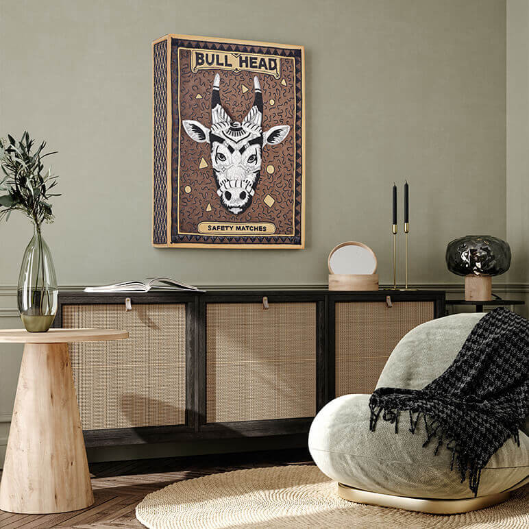 framed 3d textile wall art showcasing a reproduction of a vintage matchbox crafted in silver and black metallic wire embroidery over a brown suede background, seen displayed in a green living room