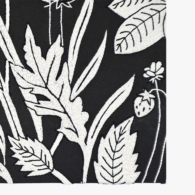 Corner view of a canvas framed minimalist wall art with wildflowers, in black and white