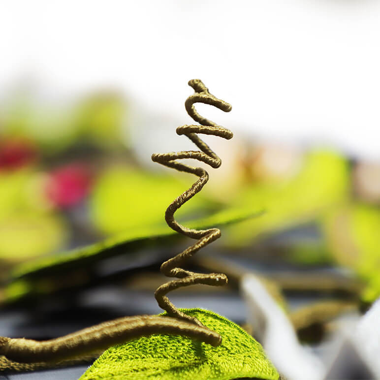 closeup view of an embroidered tendril crafted using the stump work technique