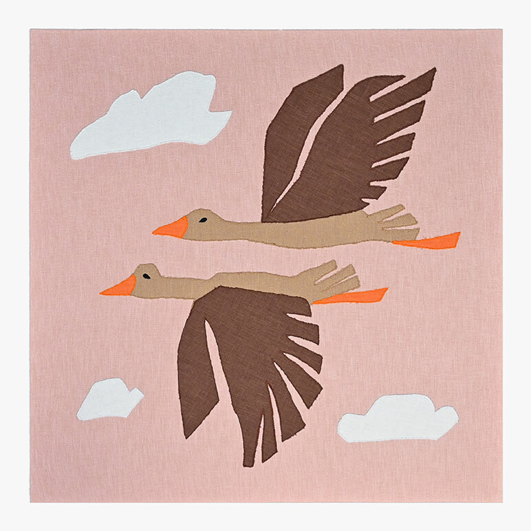 Feature image of a nature inspired nursery decor piece in the form of a textile artwork with flying birds amidst a pink sky with white clouds