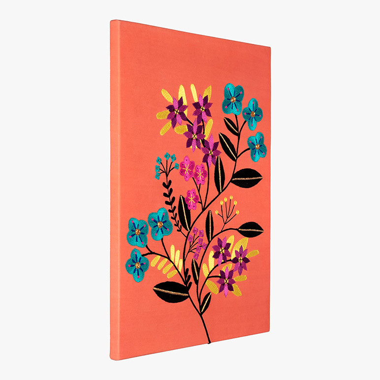 embroidered floral wall art on orange fabric seen from the side