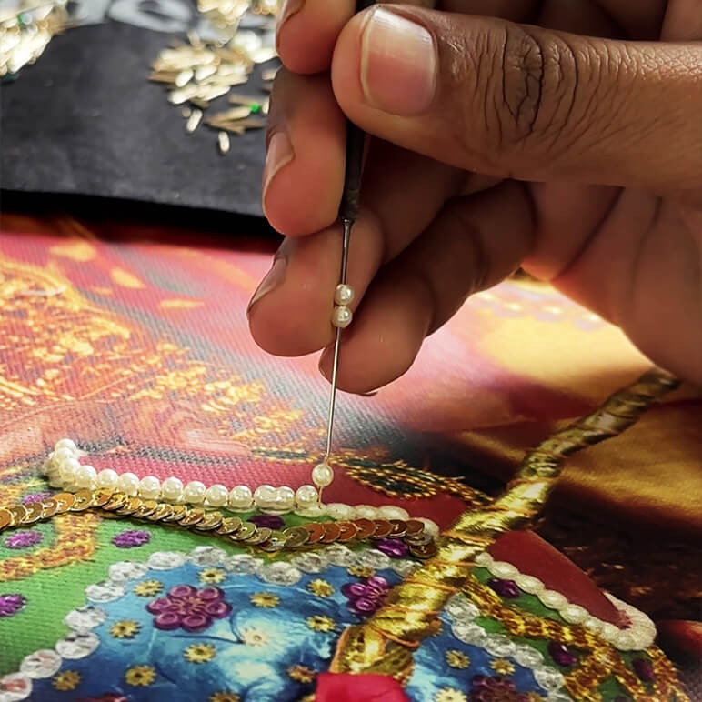 hand at work on a work in progress embroidery of a custom portrait