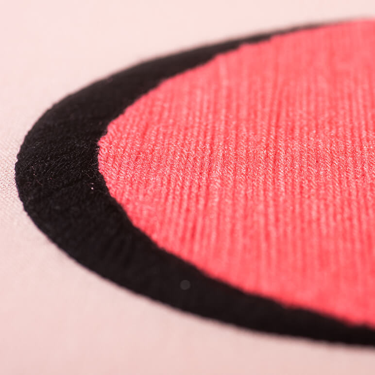 closeup view showing black and pink colored wool embroidery