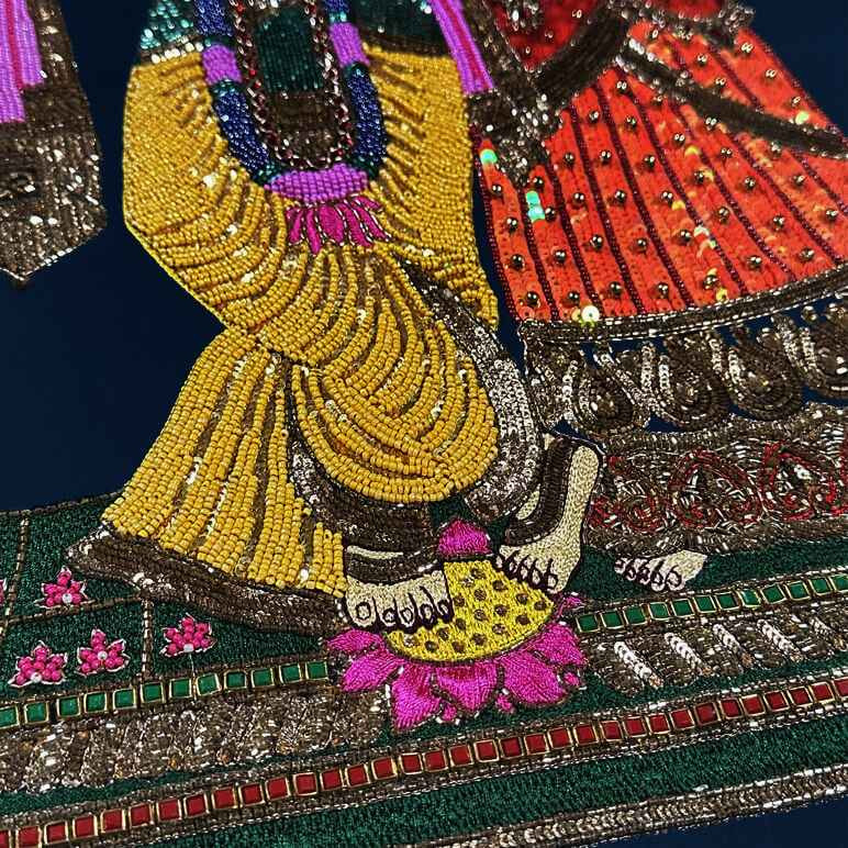 Detailed view showing the embroidery details on a Radha Krishna artwork, done in hand beading