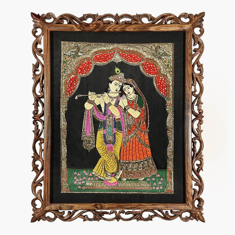 Feature image of a textile artwork showcasing Lord Krishna and Radha, hand beaded in various colours over a black fabric background and framed in a hand carved ornate dark wood frame
