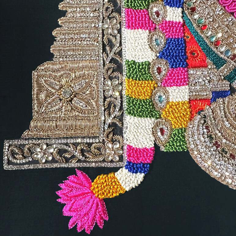 Embroidery detail in silk thread, zardozi, crystals and kundan stones seen in vibrant colours over a black raw silk background