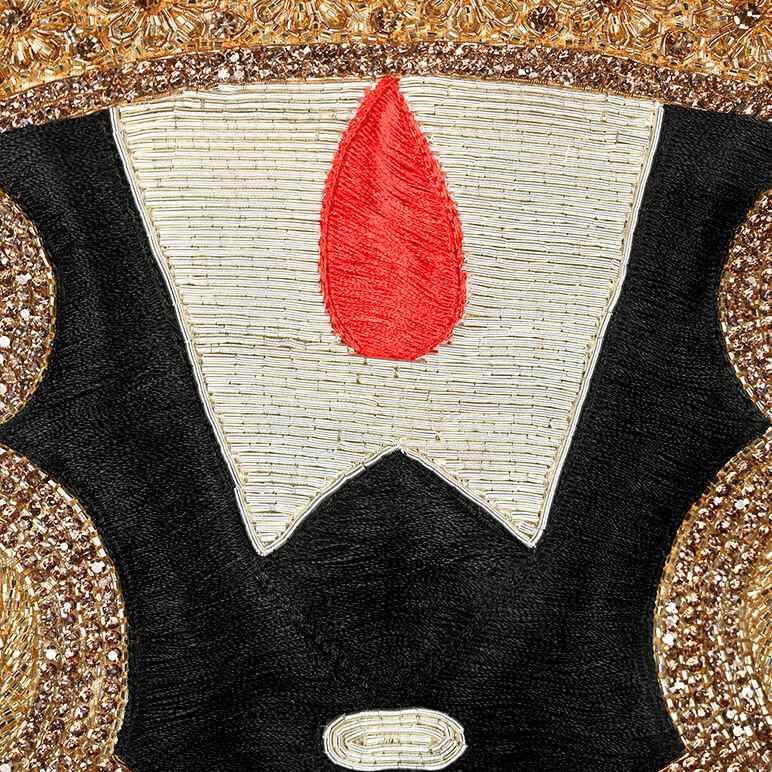 Detailed close up view of the embroidery in black, gold, silver and red done by hand on a Tirupati Balaji textile art