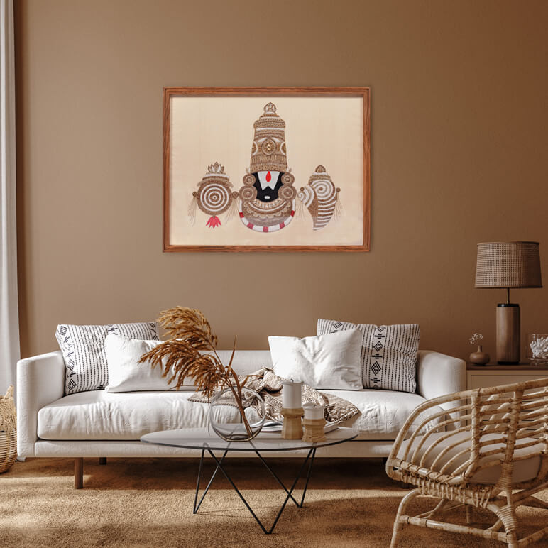 Lifestyle shot showing a Tirupati Balaji textile artwork displayed on an earthy colored wall in a modern living room