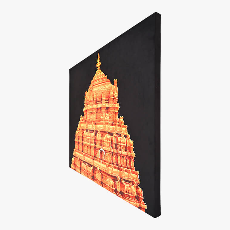 Image showcasing a textile artwork from the right angle. The artwork showcases the Tirupati Balaji Temple in gold over a deep black fabric background. It is canvas framed.