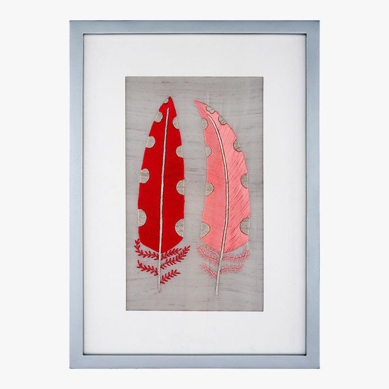 framed modern farmhouse wall art featuring two pink feathers with polka dots embroidered over a grey silk background 