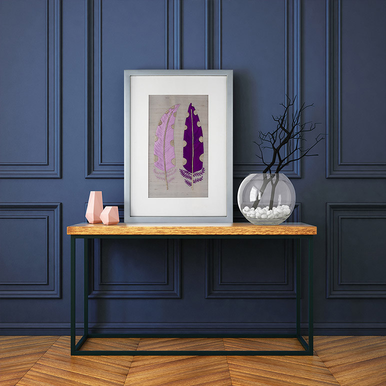 framed feather embroidery art seen in a modern blue minimalistic room
