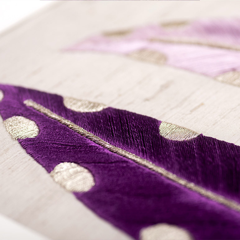 closeup view of an embroidered dark purple feather
