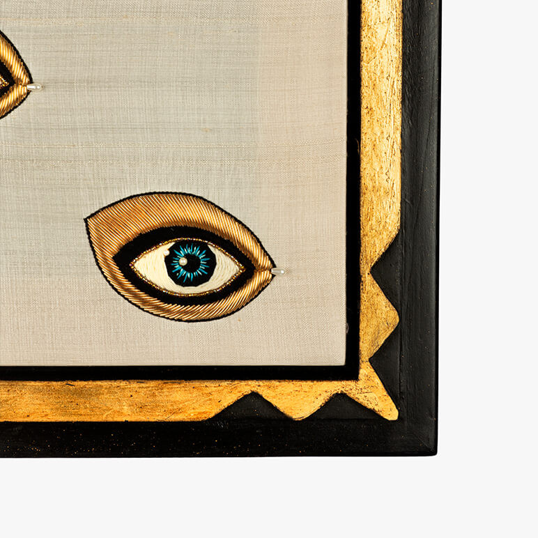 frame corner detail of a textile wall artwork with a black and gold gilded frame