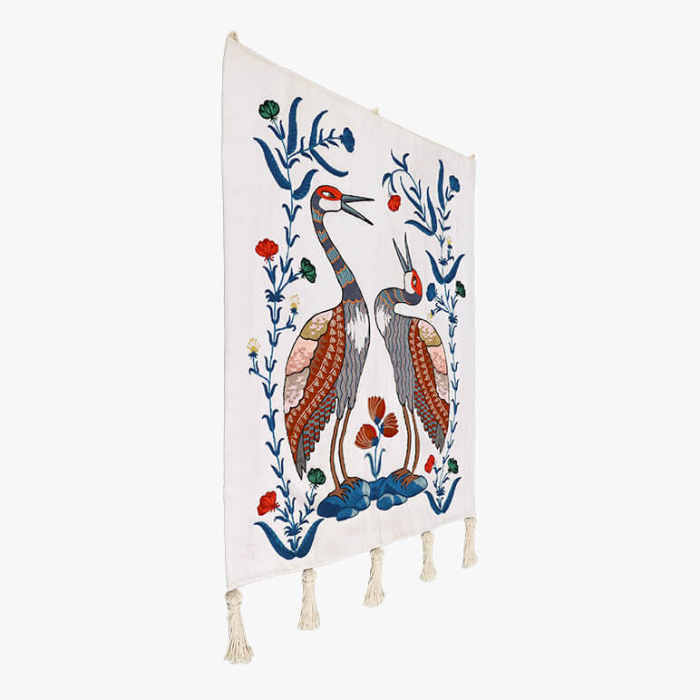 side angle view of a blue and white tapestry featuring a pair of Sandhill cranes in red, white and blue colors